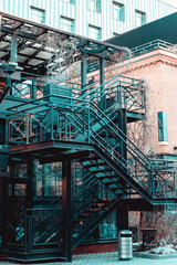 Fototapeta premium stair for fire escape with the steel railing and ladder on side of building. black outdoor metal staircase construction outside of building