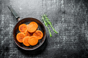 Fish cutlets in pan with rosemary.