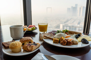 breakfast at hotel with Arabic food on the background of a beautiful view of the sights of Dubai. Beautiful view from the restaurant window.