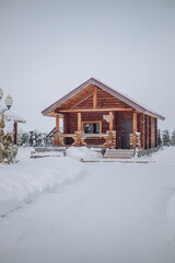 A wooden house in a snowy forest around Christmas trees