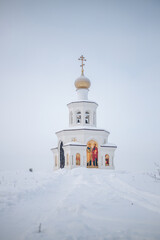 The church stands alone on a hill in the snow