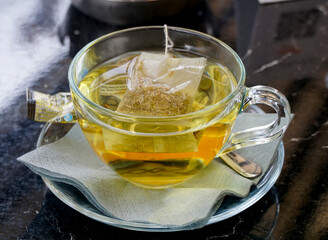 Herbal chamomile tea in a glass served in a table of cafe