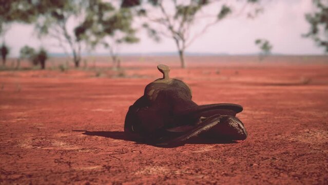 Old decorated mexican saddle lying on sand
