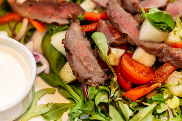 food, cooking and eating concept - close up of duck meat with vegetable salad on plate