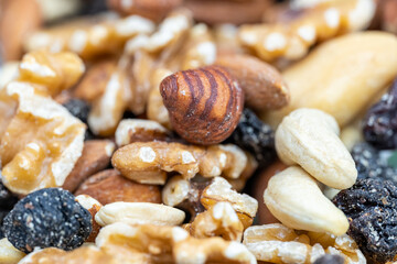 Fototapeta na wymiar Nuts stacked with hazelnuts, cashews and raisins, in a macro photograph shot.
