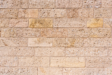 Eine alte rustikale verwitterte beige Steinmauer als ein Hintergrund