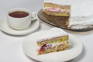Homemade cake with a cup of tea on a white background. Slice of homemade white cake