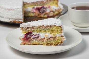 Homemade cake with a cup of tea on a white background. Slice of homemade white cake