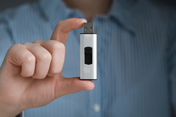 Woman holding usb flash drive, closeup view