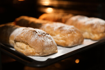 Cooking fresh crispy ciabattas in oven, closeup