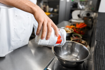 cooking food, baking and people concept - close up of male chef cook with eggs pouring flour into bowl at restaurant or bakery kitchen