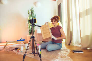 Cute ginger girl conducting an online tutorial on wood painting