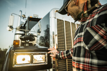 Fototapeta na wymiar Professional Driver Checking On His Semi Truck Headlights