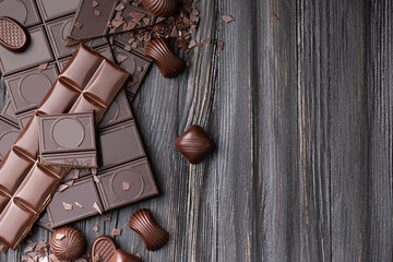 Chocolate bars and candies on a dark wooden background top view