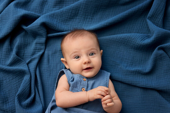 Newborn baby lying on blue cotton gauze blanket