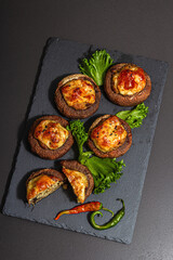 Baked stuffed mushroom caps ready for eating. Champignons, spices, vegetables, cheese