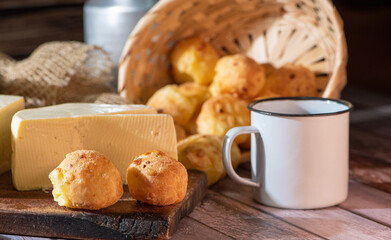 Cheese bread and more, cheese bread, manioc flour cookies and Minas cheese arranged on a rustic wooden surface with accessories, selective focus.