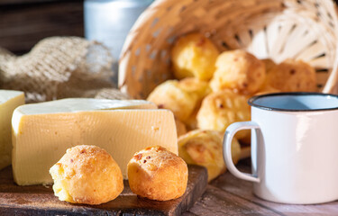 Cheese bread and more, cheese bread, manioc flour cookies and Minas cheese arranged on a rustic wooden surface with accessories, selective focus.