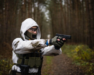 Man in a winter camo suit with a pistol