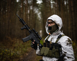 Fototapeta premium Man in a winter camo suit looking.