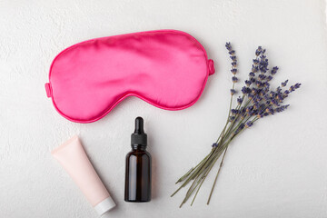 Sleep mask and lavender flowers on white textural background. The concept of sound and restful...