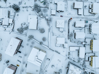 Aerial view of town with snow covered houses. Roof tops with snow on residential buildings in...