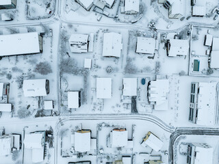 Aerial view of town with snow covered houses. Roof tops with snow on residential buildings in...