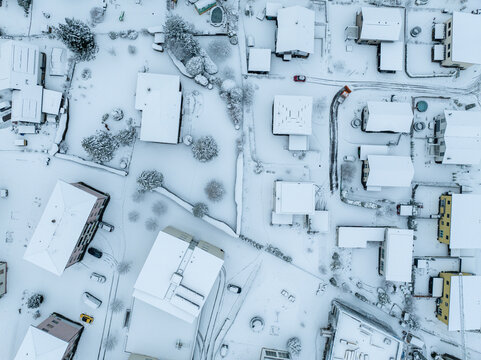 Aerial view of town with snow covered houses. Roof tops with snow on residential buildings in Switzerland.