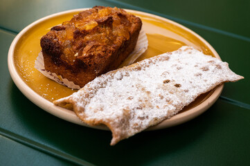One persion serving of a candied orange cake and a crusty sweet cracker , France