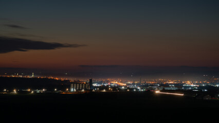 Obraz premium Illuminated city at late twilight, car light trails