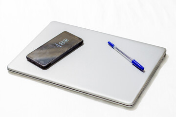 laptop, cell phone and pen on white background