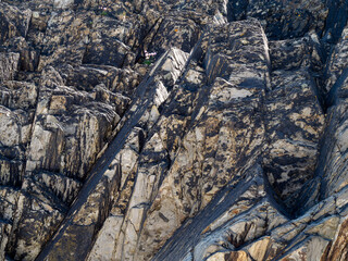 A variety of geological strata as a background. Stone texture, full frame. Brown rock