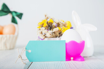 Happy Easter greeting card. Rabbits, colorful eggs, spring flowers with tag for text..