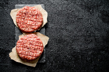Raw burgers on paper.