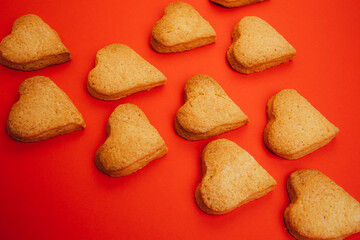 Shortbread cookies in the form of hearts on a red background. Background, Valentine's Day. Top view, selective focus