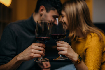 Close up photo of people toasting with a glass of vine