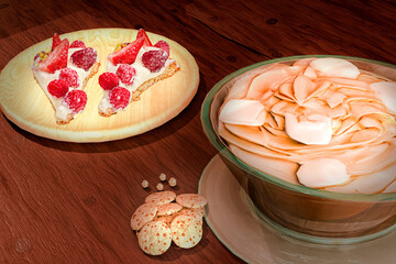 Bowl of chocolate cream shake next to plate with two slices of strawberry cookie pie. Gastronomy and confectionery. 3d render.