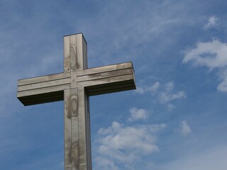A massive steel cross standing out against the blue sky © pavlazi