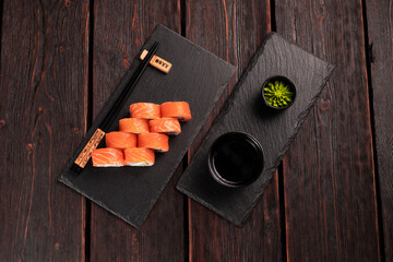 Sushi roll philadelphia with salmon and cucumber and cream cheese on black background. Sushi menu. Japanese food concept top view