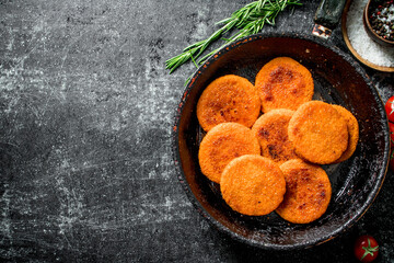Fish cutlets in pan with rosemary.