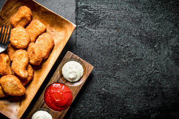 Chicken nuggets and different sauces.