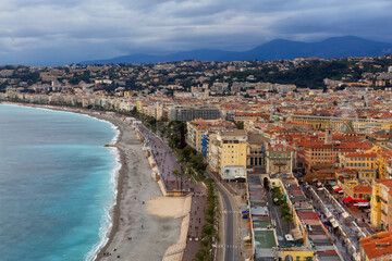 Fototapeta premium Sandy Beach by Historic City of Nice, France. View from Castle Hill. Cloudy Evening before Sunset.