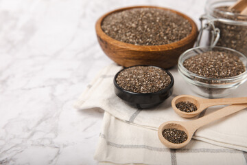 Chia seeds in a bowl and spoons on white marble. Superfood. Antioxidant. Healthy food. Proper nutrition. Diet concept. Place for text. Place to copy.