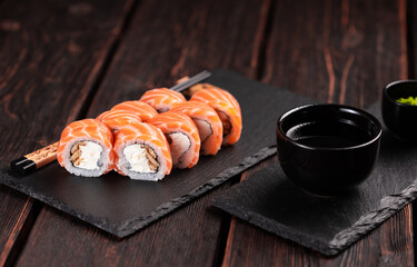Sushi roll philadelphia with salmon and eel and cream cheese on black background close-up. Sushi menu. Japanese food concept