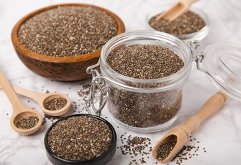 Chia seeds in a bowl and spoons on white marble. Superfood. Antioxidant. Healthy food. Proper nutrition. Diet concept. Place for text. Place to copy.