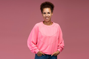 Confident portrait stylish smiling young multi-ethnic woman with afro hair isolated pink background