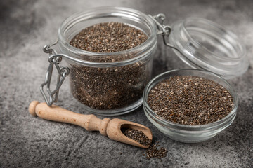 Chia seeds in a bowl and spoons on black marble. Superfood. Antioxidant. Healthy food. Proper nutrition. Diet concept. Place for text. Place to copy.