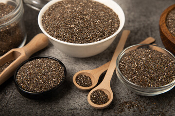 Chia seeds in a bowl and spoons on black marble. Superfood. Antioxidant. Healthy food. Proper nutrition. Diet concept. Place for text. Place to copy.