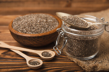 Chia seeds in jar and spoons on brown texture wood. Superfood. Antioxidant. Healthy food. Proper nutrition. Diet concept. Place for text. Place to copy. selective focus.