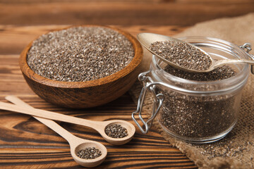 Chia seeds in jar and spoons on brown texture wood. Superfood. Antioxidant. Healthy food. Proper nutrition. Diet concept. Place for text. Place to copy. selective focus.